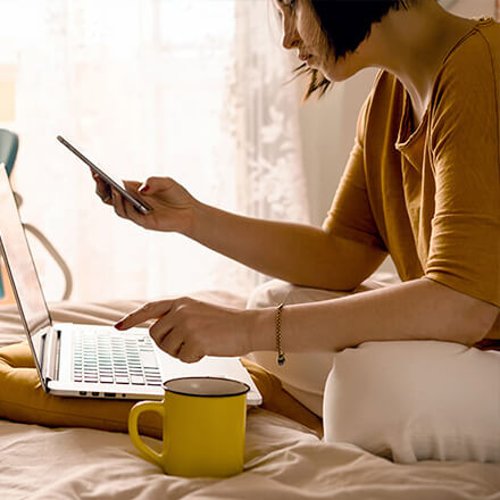 Stock image of woman on phone and laptop